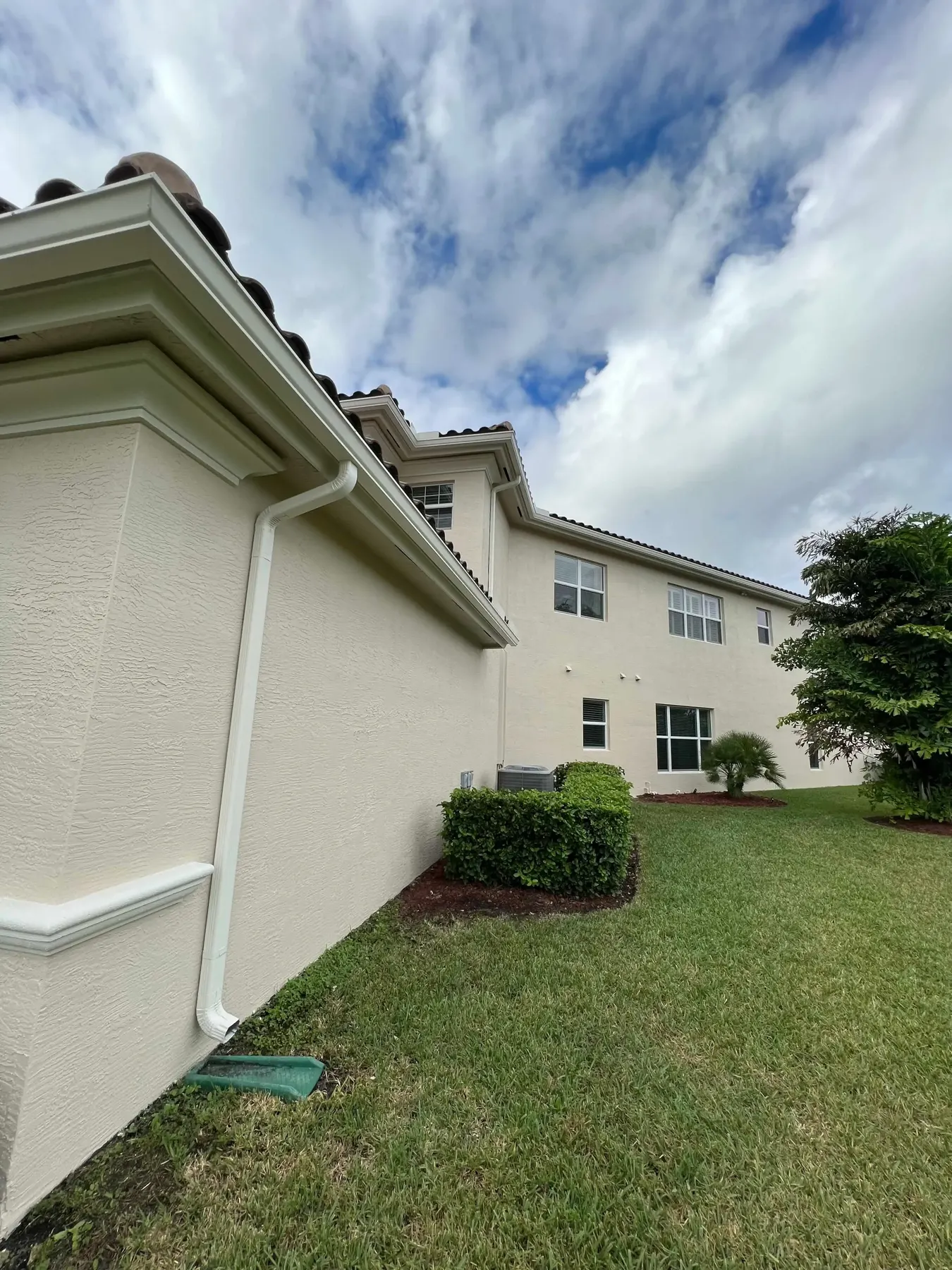 Close-up of a freshly painted stucco home exterior with crisp gutter and trim lines