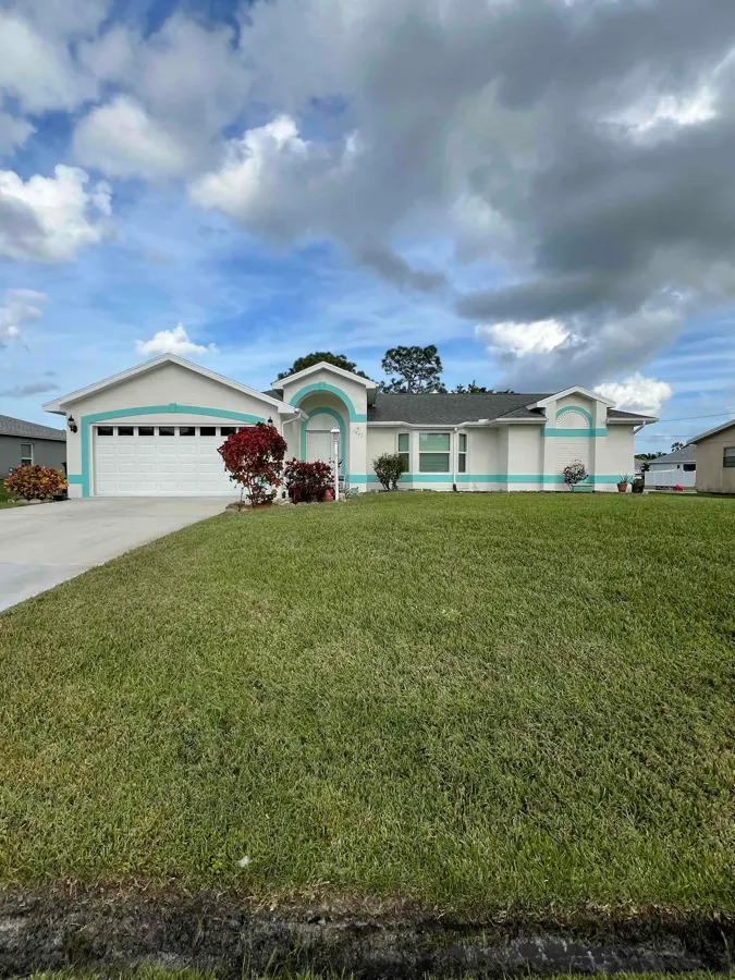 Single-story home painted cream with teal trim accents
