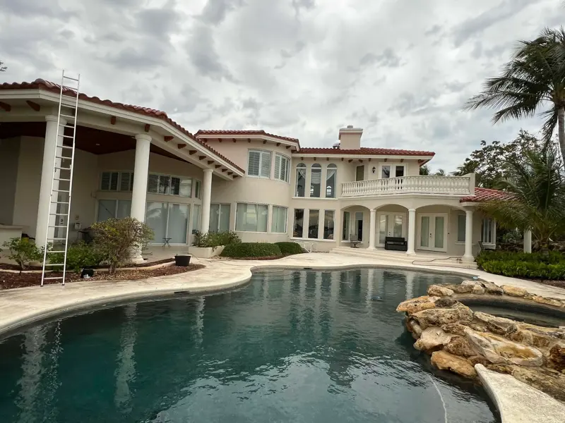 Large home exterior overlooking a pool and patio