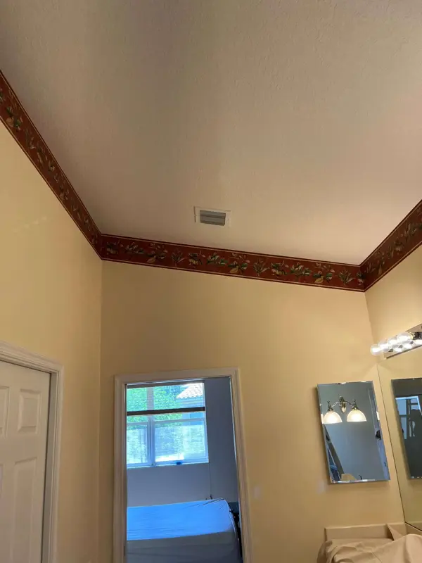 Freshly painted cream bedroom and bathroom with existing decorative trim preserved