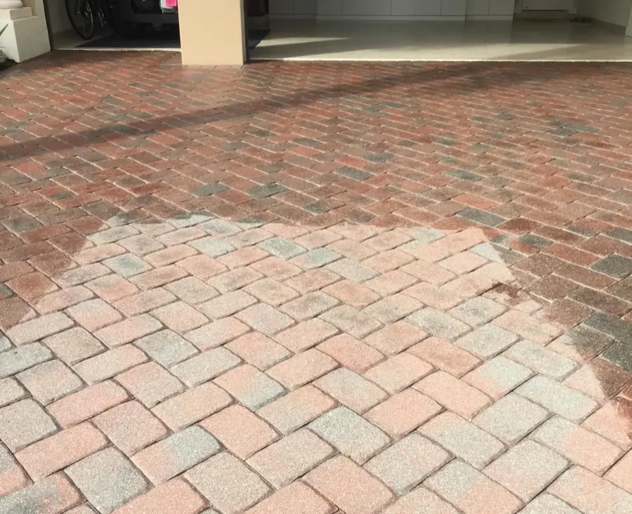 Red brick paver driveway leading to a garage